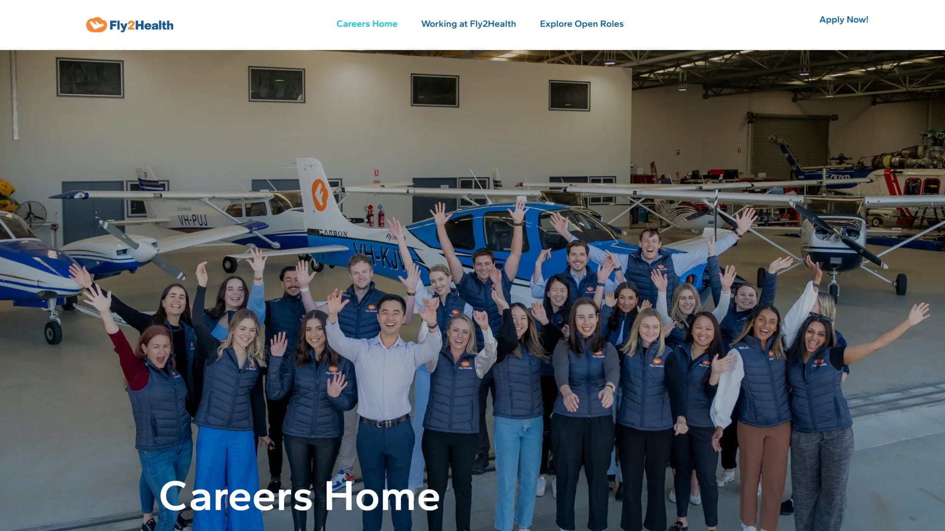Fly2Health Careers Home page showing the team waving in an aircraft hangar